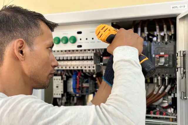 Electrician lucrând la un tablou electric
