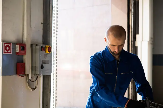 Tehnician de mentenanță lângă panourile tehnice ale unei clădiri